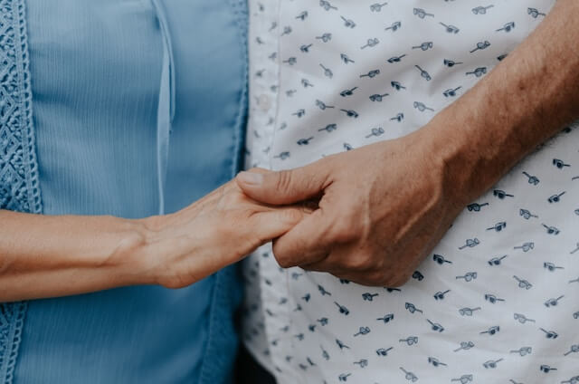 老夫婦が手を握り合う画像