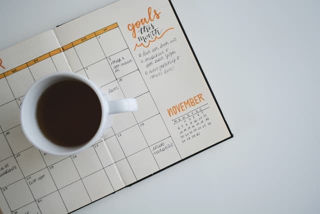 スケジュール帳にコーヒーが載っている画像
