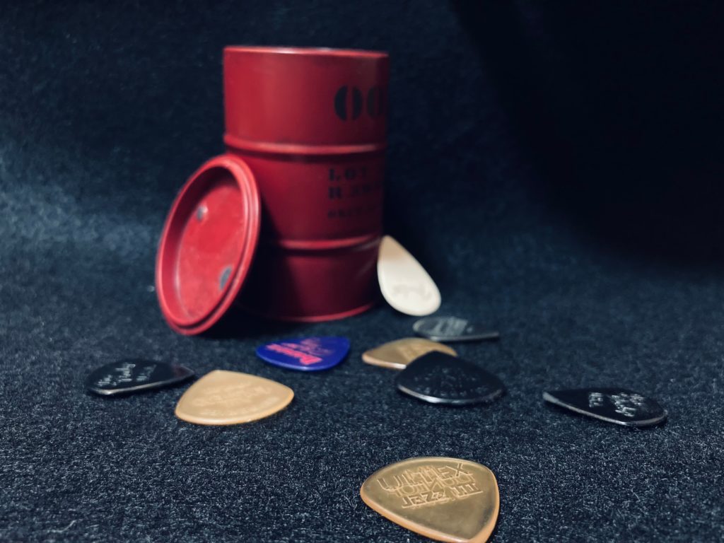 ミニチュアのドラム缶の周りに散らばるダンロップのJazz IIIピック